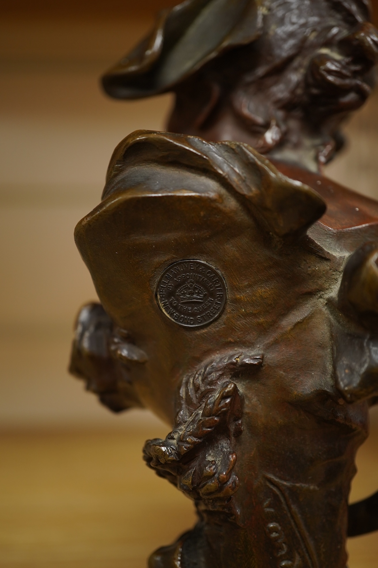 A late 19th century bronze bust of a lady in a hat with floral decoration , mounted on marble, signed, 21.5cm high.